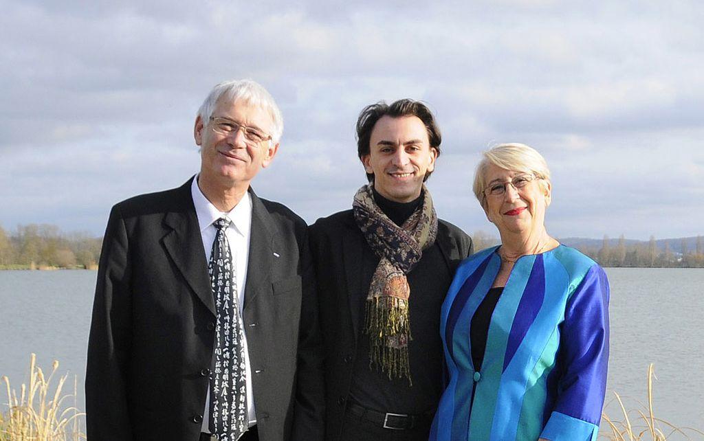 Jean-Marc et Martine Thérouanne, du festival des cinémas d'Asie de Vesoul, encadrent Nicolas Carrez-Parmentelot, en 2014. | ©CC BY-SA 4.0 Deed 