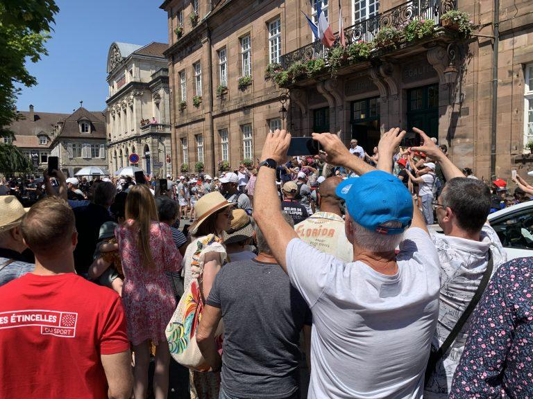 Devant la mairie, les passants tentent de prendre une dernière photo, avant que le cortègene s'engouffre avenue des Alliés.