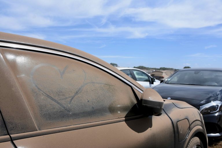 Sur le parking du camping, les voitures des festivaliers sont recouvertes de poussières. | ©Le Trois - A.S.