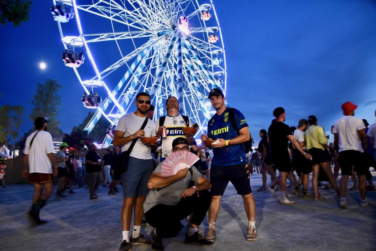 Des fans de Sochaux sont présents en nombre aux Eurockéennes. Ils posent devant la grande roue illuminée. | ©Le Trois – AS