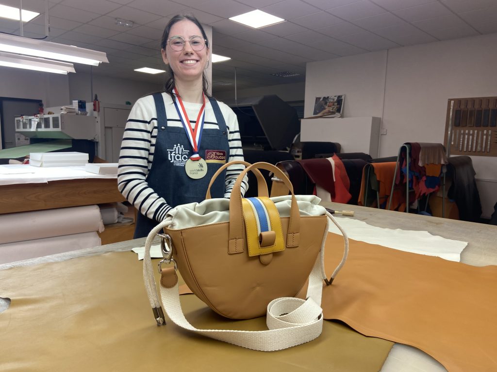 Maude Vienet devant le sac qu'elle a conçu pour les WorldSkills France.
