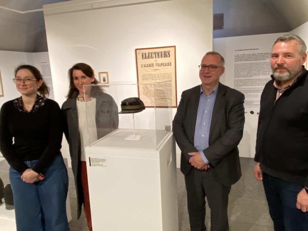 Cécile Griessmann, directrice du musée de la citadelle de Belfort, Delphine Mentré, adjointe chargée de la culture, Damien Meslot, maire de Belfort et Jérôme Marche, responsable de l'action culturelle (de gauche à droite) entourent le képi du colonel Denfert-Rochereau exposé au musée. | © Le Trois P.-Y.R.