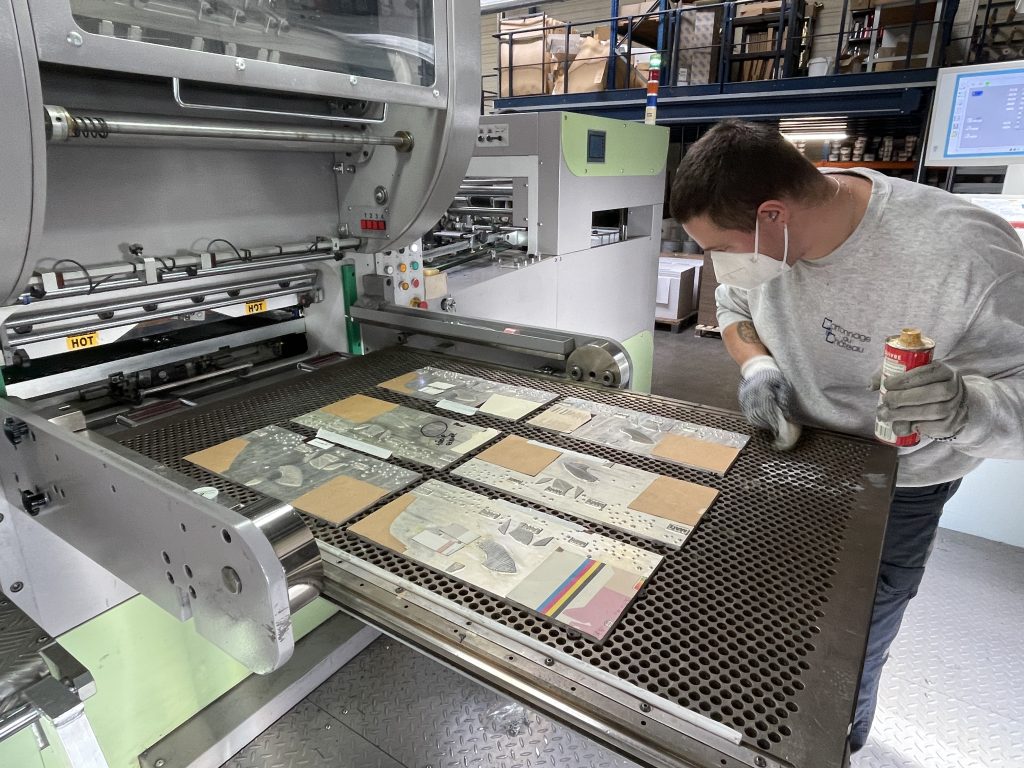 Un opérateur de Cartonnage du château, à Belfort, nettoie les plaques de dorure à froid.