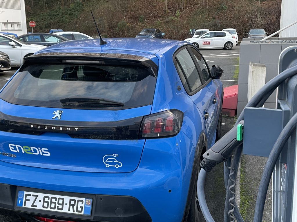 Une voiture électrique du parc Enedis à Montbéliard, près d'une borne de recharge.
