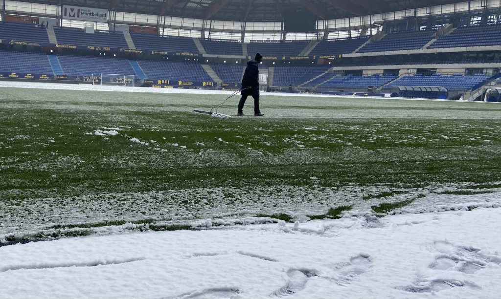 Des membres de l'équipe retirent le surplus de neige avant la rencontre de samedi 10 janvier contre le RC Lens.