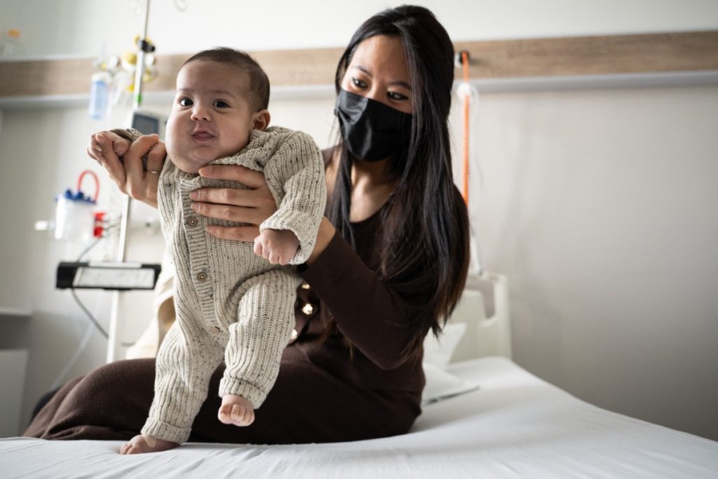 Viviane tient son bébé de 3 mois, Issa, au service d'hospitalisation pédiatrique de jour du Groupe Hospitalier de la Region de Mulhouse et Sud-Alsace, le 16 février à Mulhouse. Issa, qui avait une affection vasculaire rare, risquait de mourir. Elle a été opérée in utero, une première.