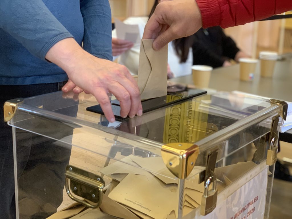 Bulletin de vote glissé dans l'urne du bureau de vote de la salle des fêtes, à Belfort, le 15 mars 2026, lors du 1er tour des élections municipales 2026.