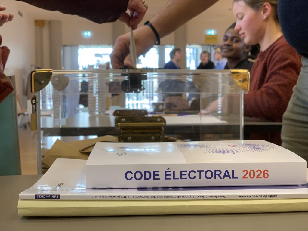 Bulletin de vote glissé dans l'urne du bureau de vote de la salle des fêtes, à Belfort, le 15 mars 2026, lors du 1er tour des élections municipales 2026.