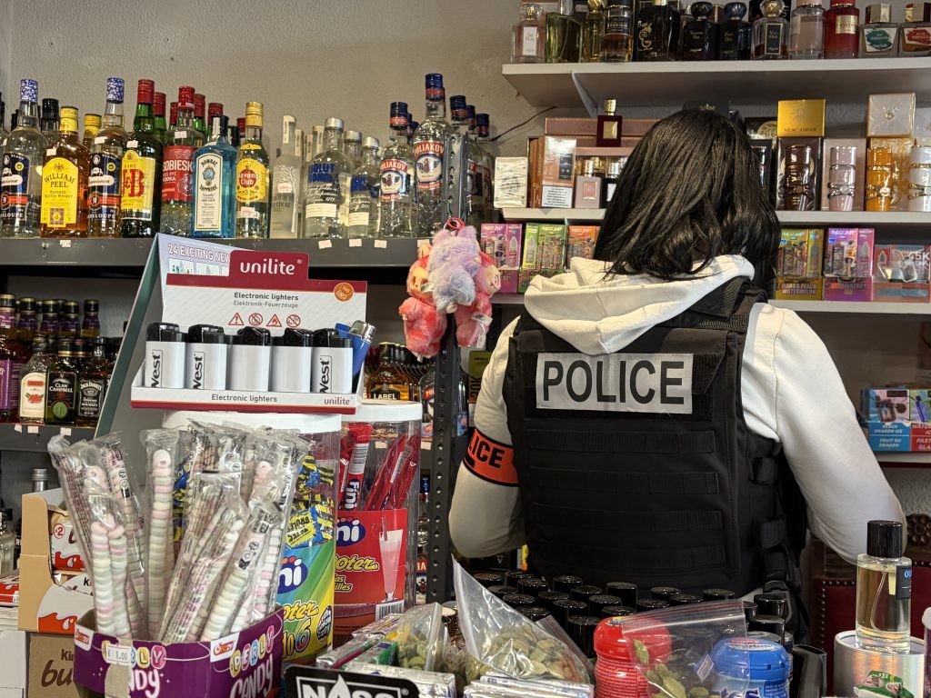 Une policière contrôle la marchandise du commerce.