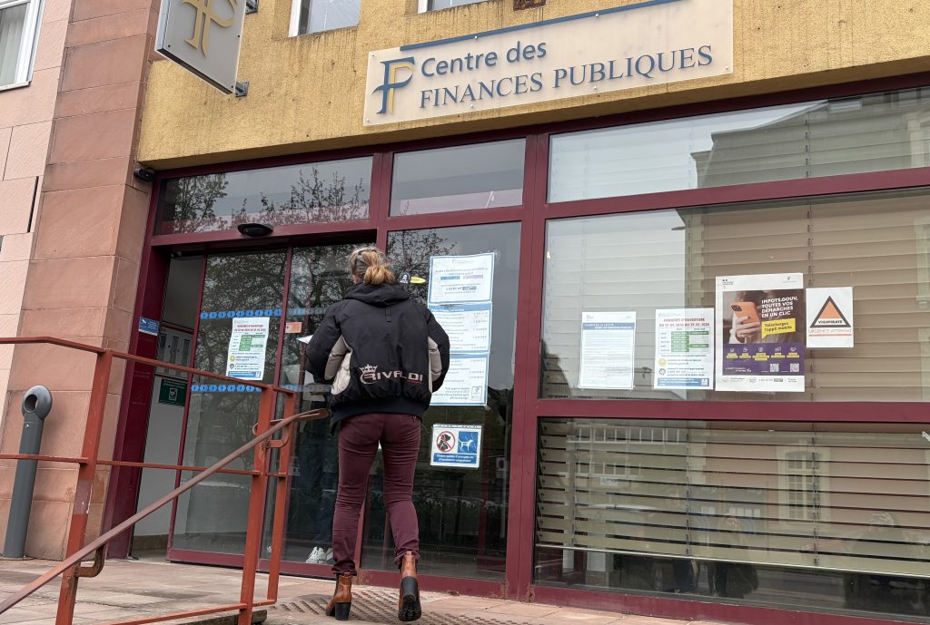 Une femme entrant dans le centre des finances publiques du Territoire de Belfort.