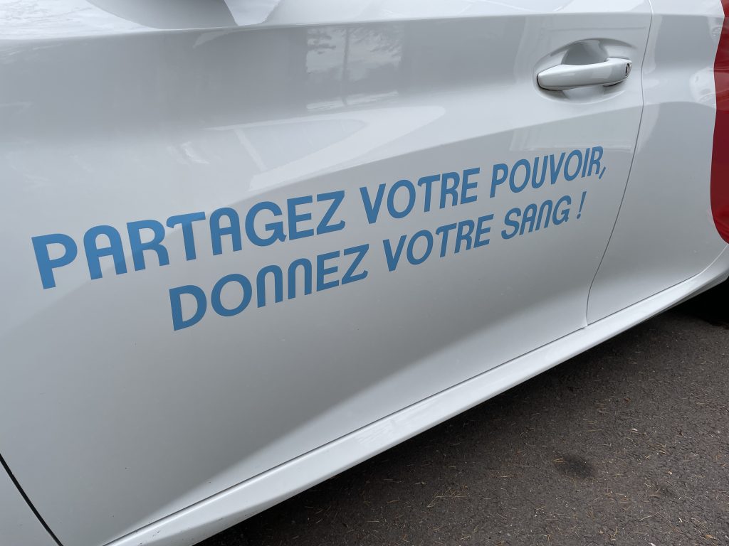 "Partagez votre pouvoir, donnez votre sang!": le slogan de l'Etablissement français du sang (EFS) sur le flan d'une voiture.