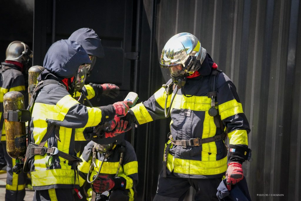 Des pompiers du Doubs se déséquipent en sortant du caisson feu, lors d'une formation au centre de secours de Belfort Sud.