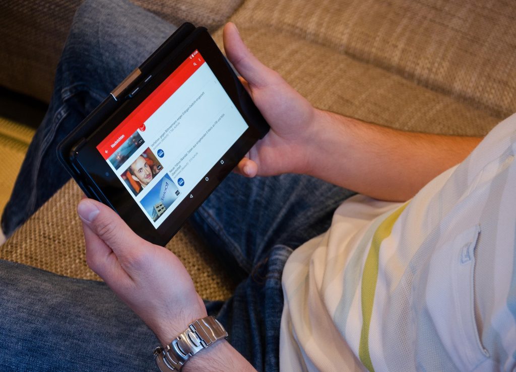 Un lecteur lisant de la presse en ligne, sur une tablette.