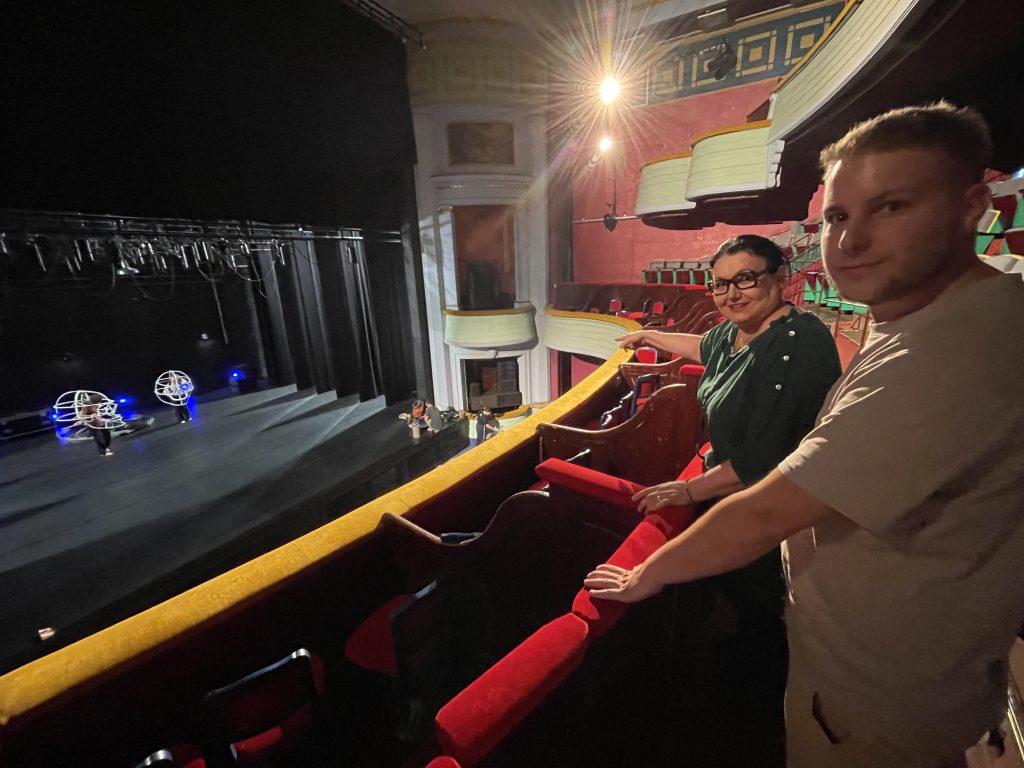 Eleonora Rossi, directrice du théâtre Grranit, scène nationale, de Belfort, et Romain Holubco, chargé de communication, dans la salle de spectacle, tandis qu'une troupe bisontine prépare un spectacle.