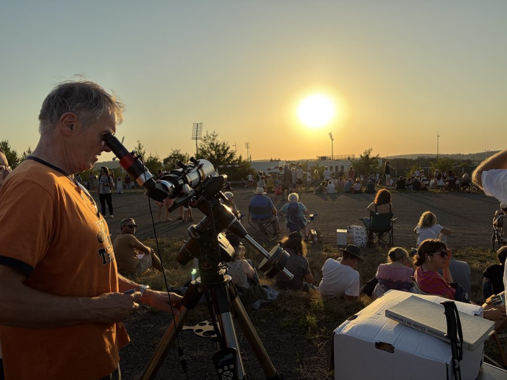 Une personne regardant l'éclipse solaire via un télescope.