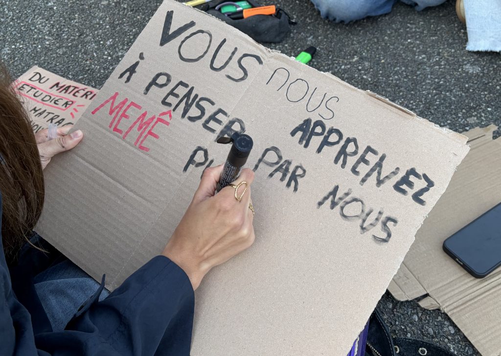 Une lycéenne préparant une pancarte pour la mobilisation.