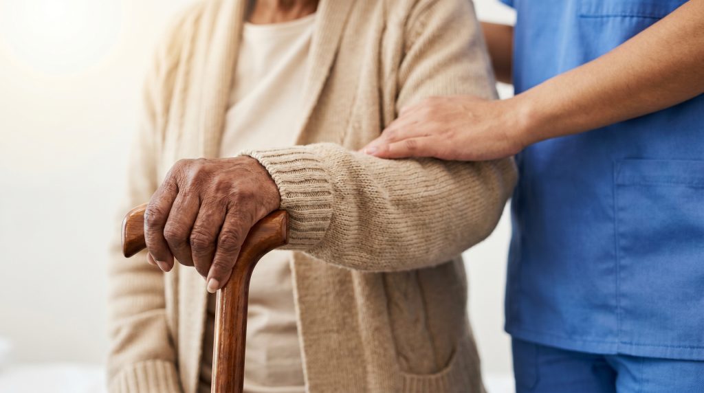 Un soignas accompagnant une personne âgée.